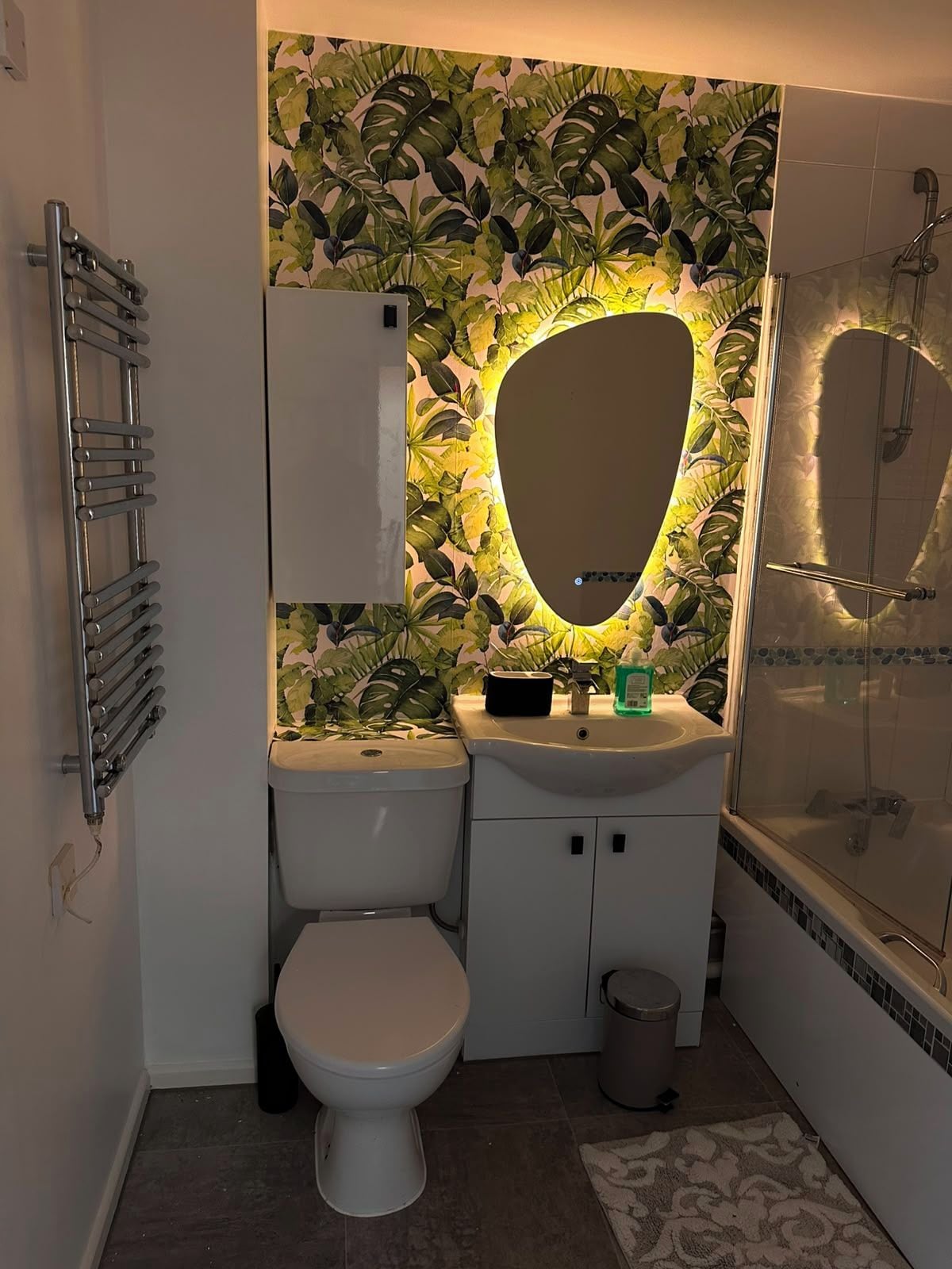 Een badkamer met toilet, wastafel en douche.