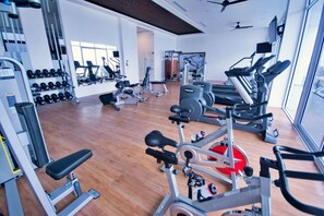 Ein Fitnessstudio mit verschiedenen Trainingsgeräten, darunter Laufbänder, Ergometer und Kraftgeräte.