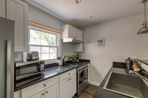 Cocina compacta equipada con microondas, tostadora, estufa y lavabo.