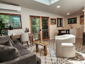 Un salon moderne comprenant un canapé, une table basse et un coin repas avec une table et des chaises.