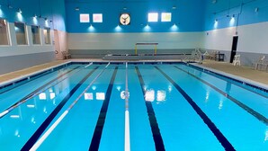 Una piscina con corsie, un trampolino e un'area spogliatoi.