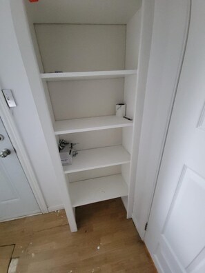 A white door with a shelf unit inside.