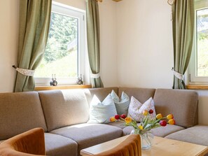 Eine Sitzecke mit einer Couch, einem kleinen Tisch und einer Vase mit Blumen.