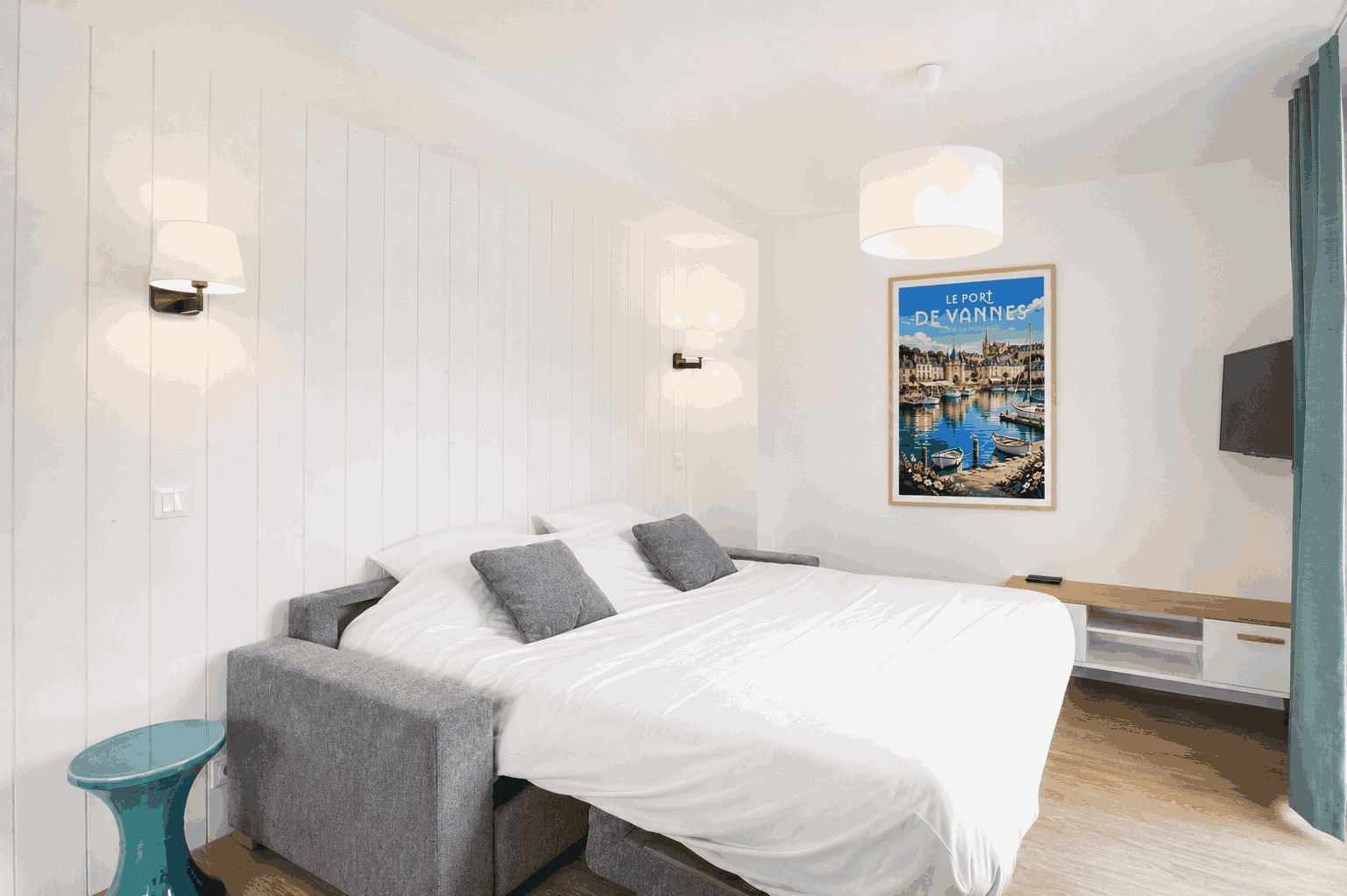 Une chambre à coucher moderne avec un lit, des tables de chevet, un téléviseur fixé au mur et une affiche.
