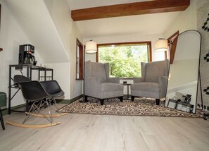 A cozy room with two armchairs, a coffee machine, and a large mirror. - Beautiful & quiet 3-bedroom house in downtown Talkeetna perfect for any getaway (Talkeetna)