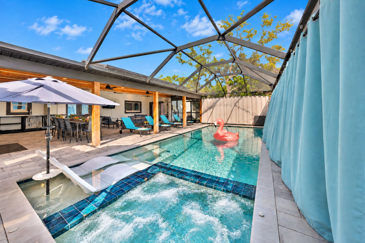 Piscina com hidromassagem, espreguiçadeiras e boia de flamingo.