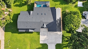 Ein modernes Gebäude mit flachem Dach, einem Schwimmbad und einem gepflegten Rasen.