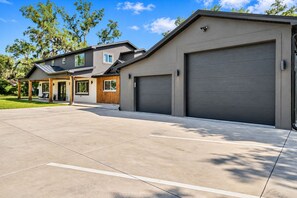 Ein modernes Wohngebäude mit überdachter Veranda, Garage und gepflegter Auffahrt.
