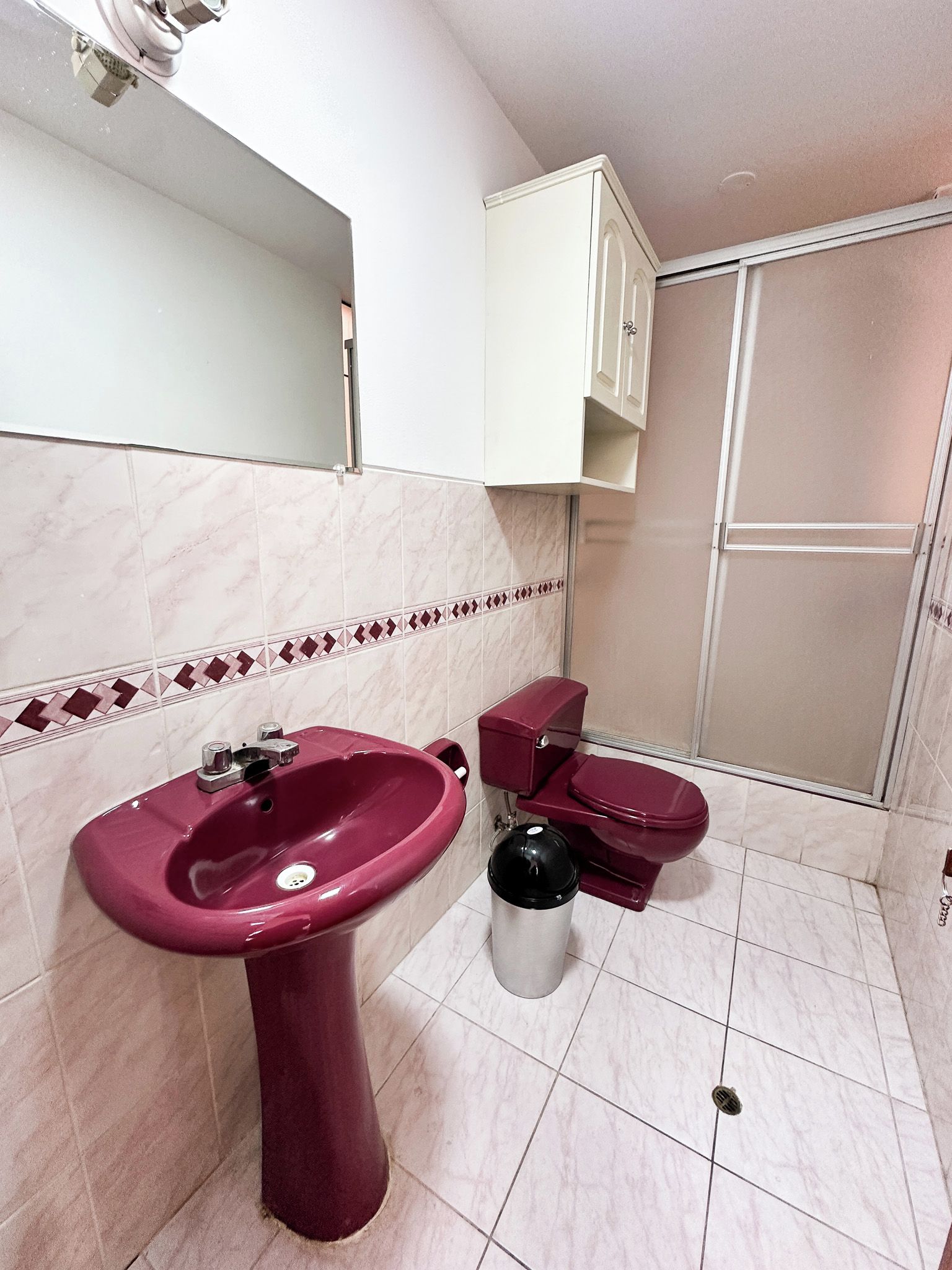 A bathroom with a pedestal sink, a toilet, and a shower enclosure.
