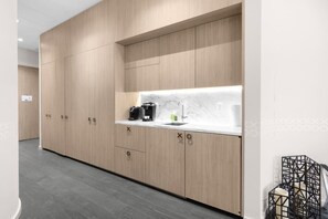 A modern kitchen with wooden cabinets, a marble countertop, and a coffee machine. - Stunning King Suite Brieckell (Miami)