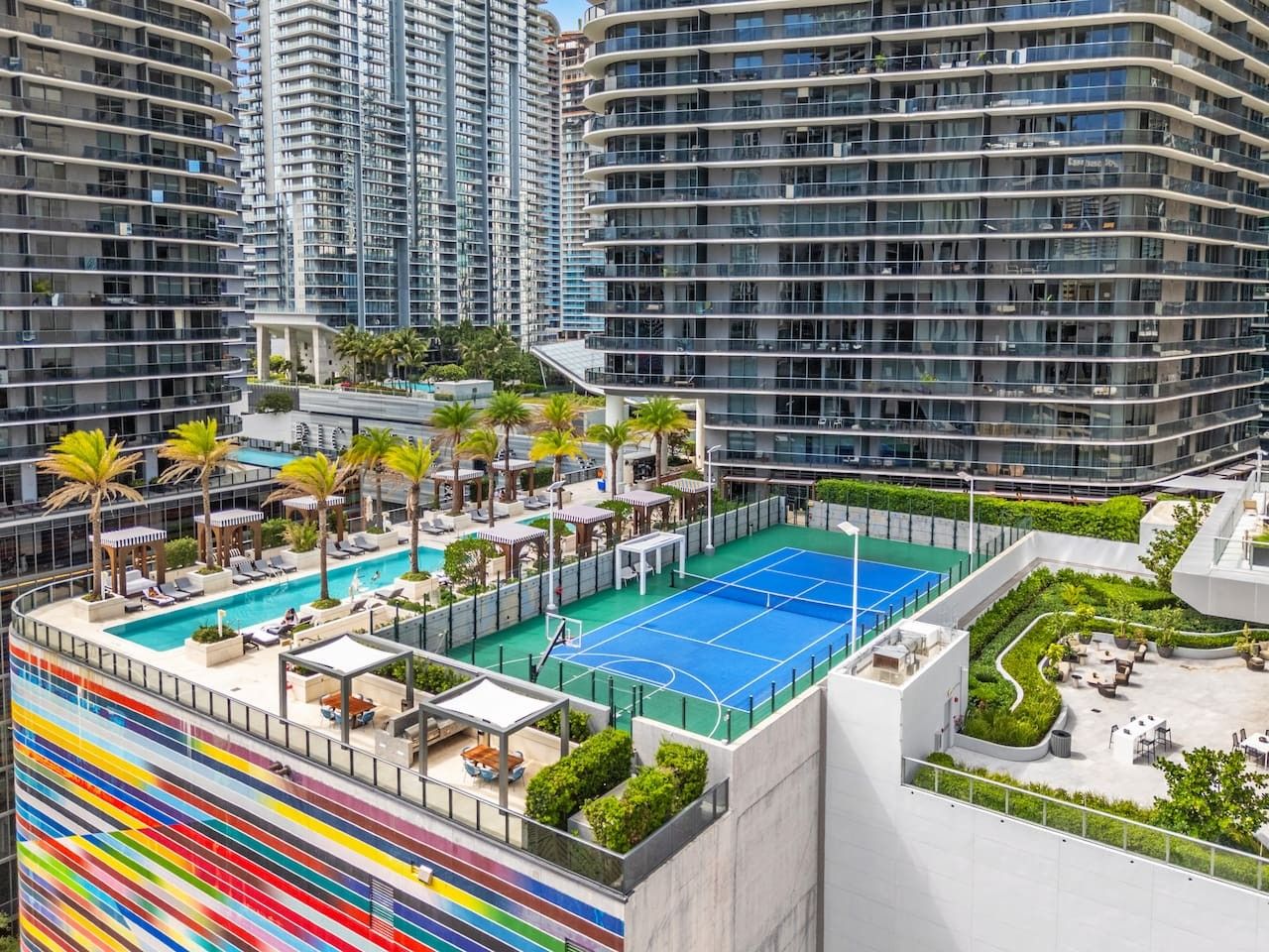 Un toit-terrasse aménagé avec un court de tennis, des espaces de détente et une piscine.