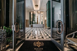 A hotel lobby with a geometric patterned floor, a reception desk, and a chandelier. - Stunning King Suite Brieckell (Miami)