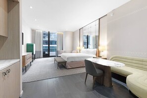 A hotel room with a bed, a desk, a chair, a sofa, and a large window with a view of the city. - Stunning King Suite Brieckell (Miami)