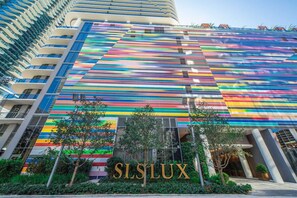 A multi-story building with a colorful facade and the name 'SLSLUX' prominently displayed. - Stunning King Suite Brieckell (Miami)
