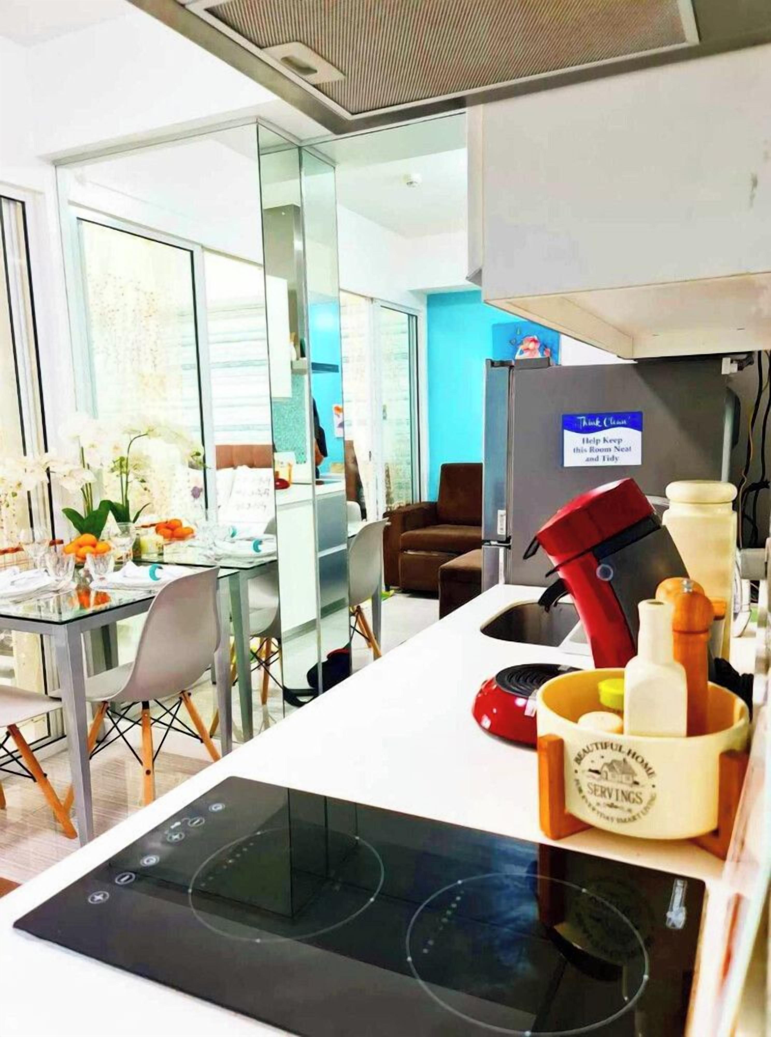 Cozinha moderna com fogão embutido, máquina de café e aviso para manter o espaço organizado.