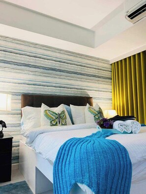 A modern hotel room with a bed, a headboard, a nightstand, and a window with curtains. - 1BR Premium Suite w Patio (Paranaque)