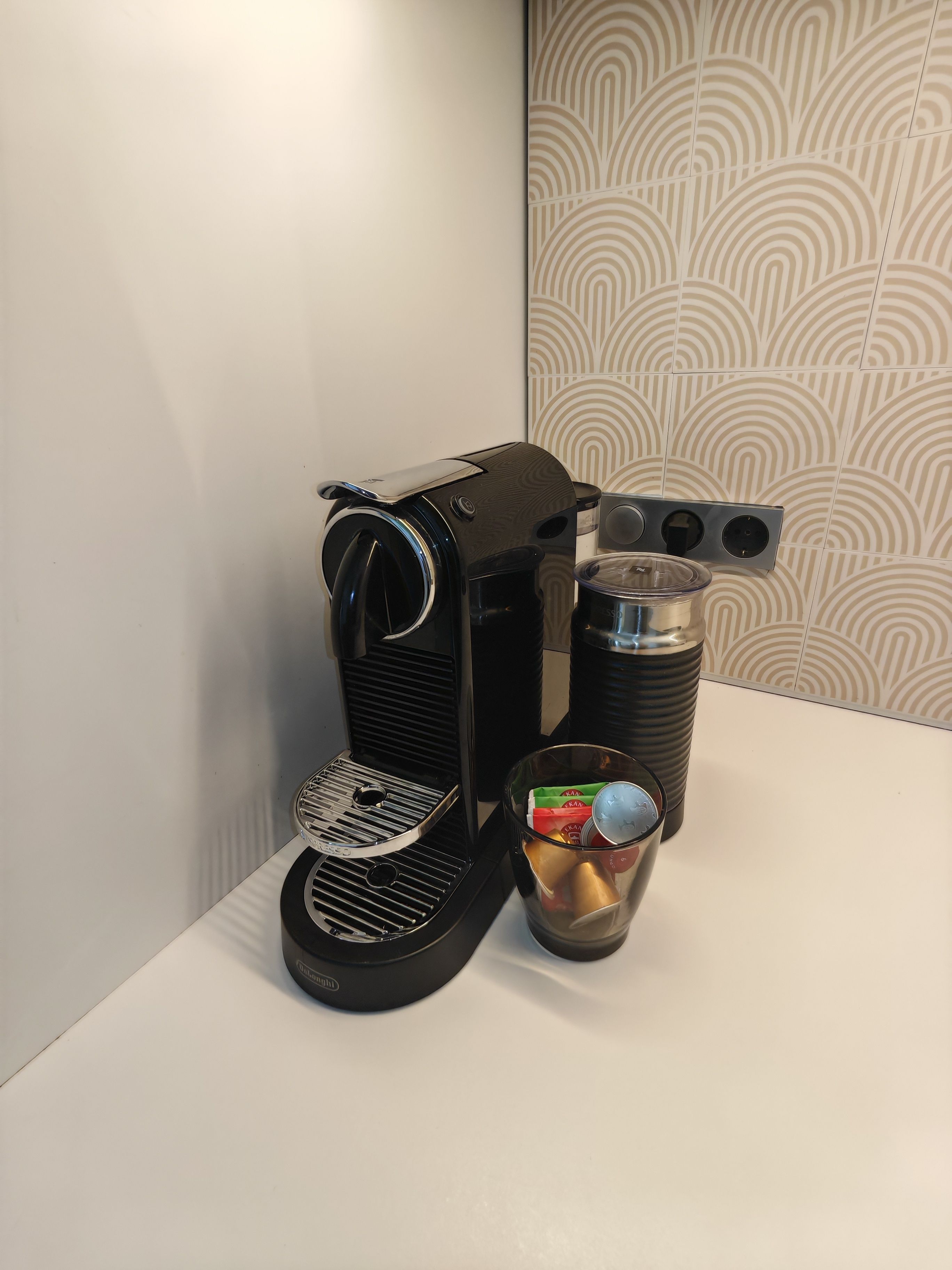 Eine Kaffeemaschine mit Wasserbehälter und Kaffeekanne auf einer weißen Arbeitsplatte.
