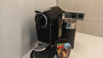 Eine Kaffeemaschine mit Wasserbehälter und Kaffeekanne auf einer weißen Arbeitsplatte.