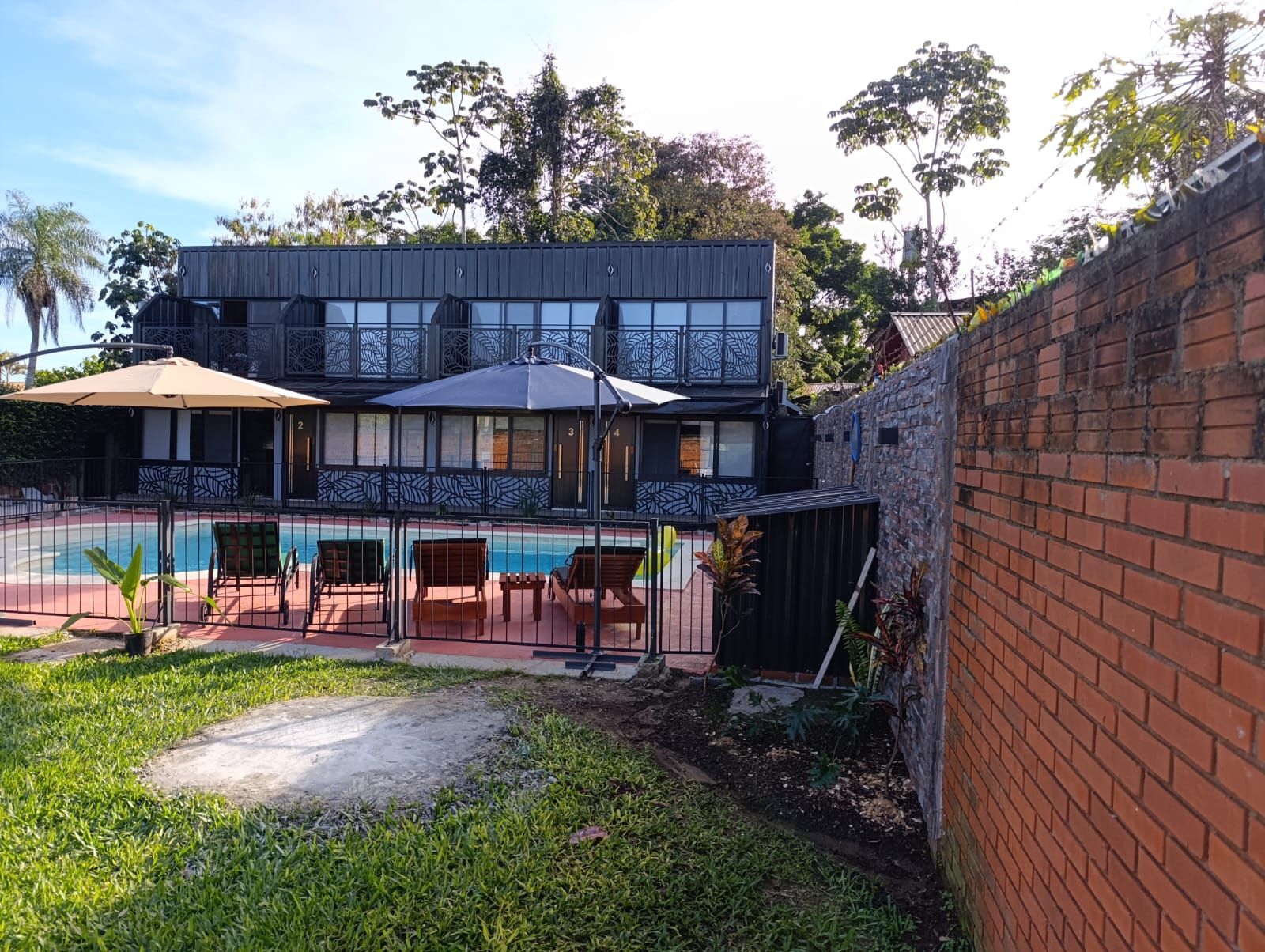 A two-story building with a swimming pool and outdoor seating.