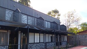 Un edificio a due piani con piscina, caratterizzato da un design moderno e motivi geometrici sulle ringhiere del balcone.