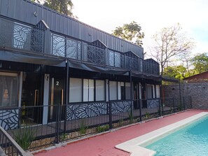 A two-story building with a pool, featuring a modern design with geometric patterns on the balcony railings. - Güigüa Apart-Hotel (Puerto Iguazú)