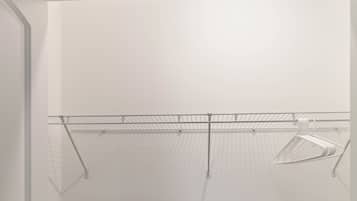 Een kamer met een houten vloer, witte wanden en een metalen rek.