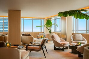 Ein stilvoller Lounge-Bereich mit verschiedenen Sitzgelegenheiten, großen Fenstern und Zimmerpflanzen.