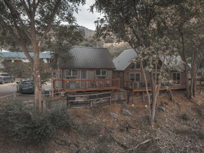 Eine Holzhütte mit Metalldach, einer Holzdiele und einer Steintreppe, die zum Eingang führt.