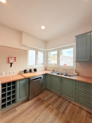 A kitchen with a dishwasher, a sink, and a window. - Beachfront home in Buarcos Beach! Perfect for families, pets, and groups! (Buarcos)
