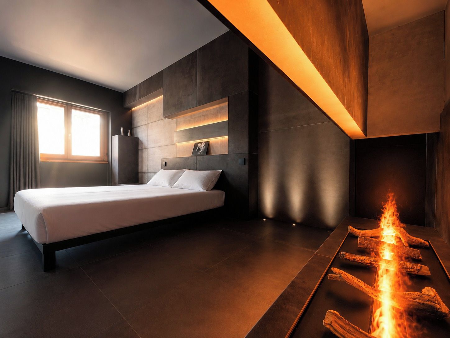 Un dormitorio moderno con cama, chimenea y ventana.