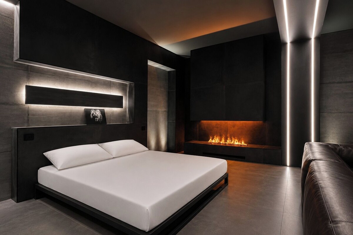 Quarto moderno com uma cama grande, lareira e parede em tom escuro.