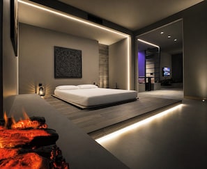 Quarto moderno com cama, obra de arte na parede e lareira embutida.