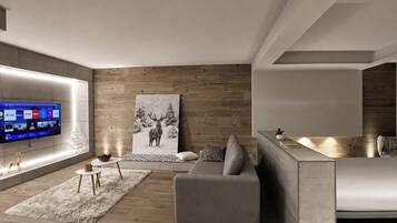 A modern living room with a flat-screen TV, a gray sofa, a wooden accent wall, and a large deer painting.