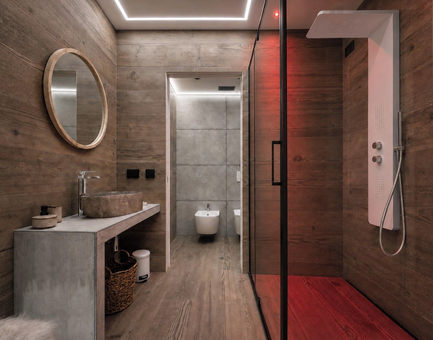 A modern bathroom with a wooden floor, a round mirror, a freestanding sink, and a glass-enclosed shower area.