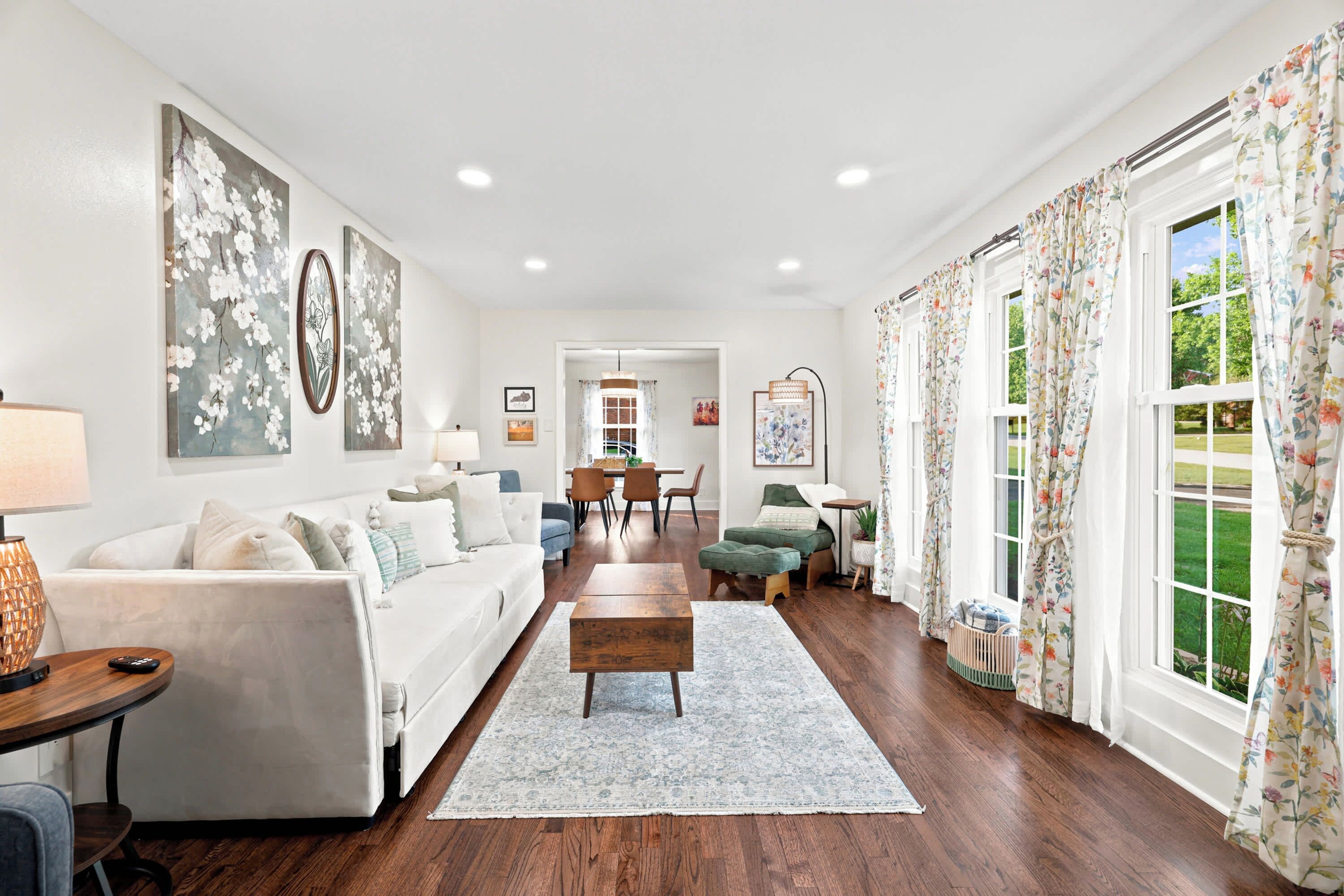 A spacious living room with a sofa, a coffee table, and a dining area with chairs.
