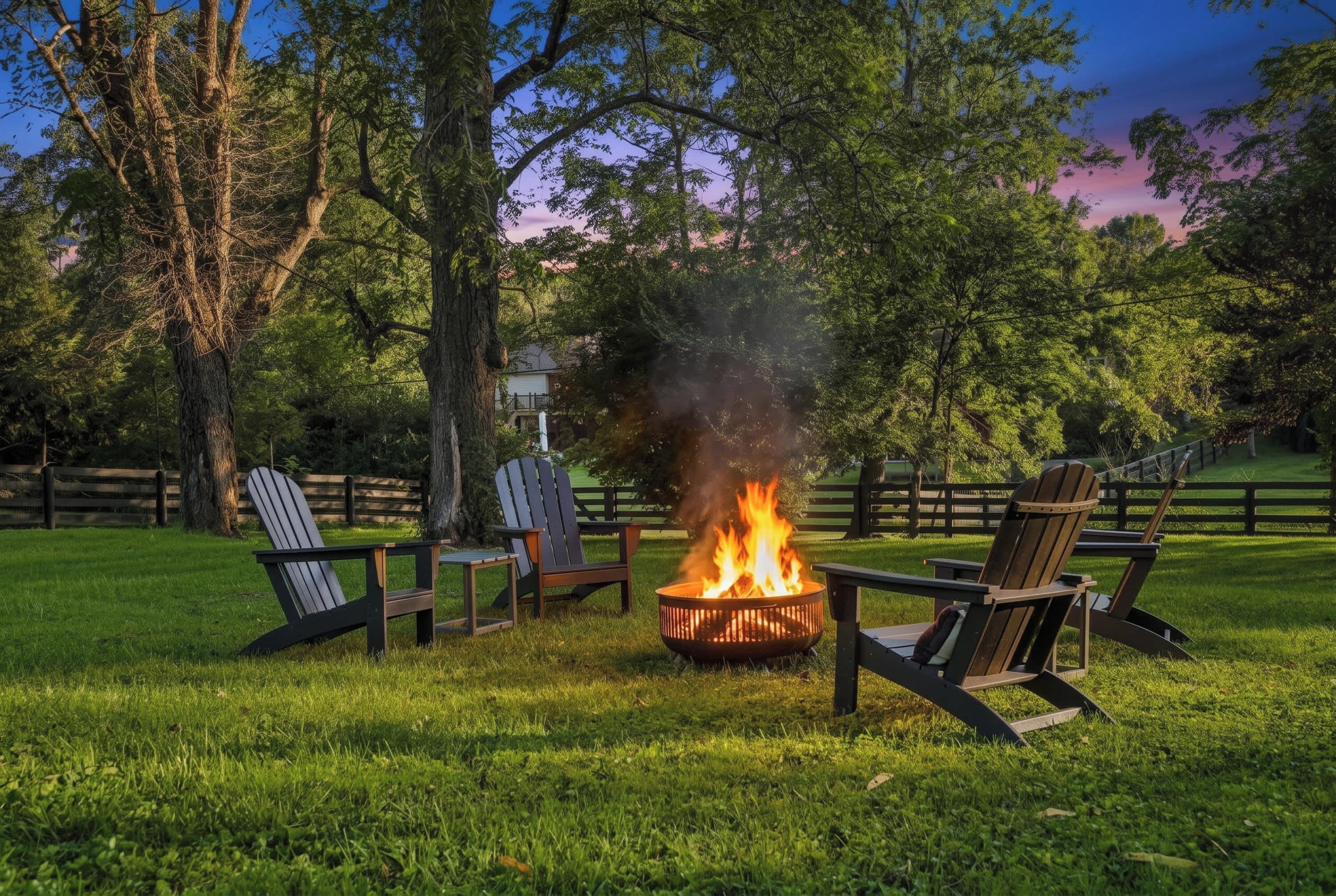 A fire pit with chairs around it in a grassy outdoor area.