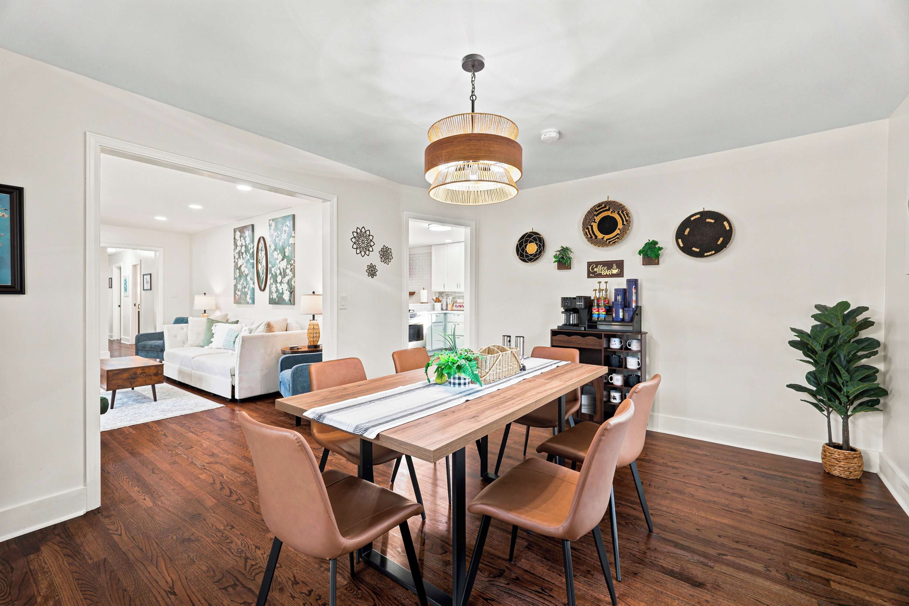 Un espace repas comprenant une table en bois, des chaises et un luminaire suspendu.