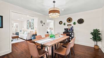 Un espace repas comprenant une table en bois, des chaises et un luminaire suspendu.