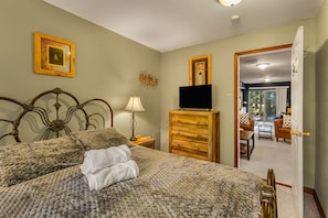 A bedroom with a bed, a dresser, a television, and a door leading to a balcony. - Thanksgiving Open! 6-bedroom, 2 Kitchens, Hot Tub, Game Rm, Piano, Fire Pit,  (Pocono Lake)
