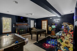 A room with a foosball table, a television, and a foosball table with a colorful mural. - Thanksgiving Open! 6-bedroom, 2 Kitchens, Hot Tub, Game Rm, Piano, Fire Pit,  (Pocono Lake)