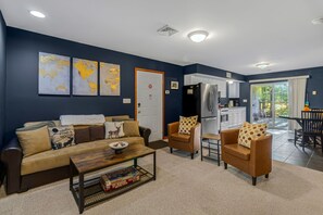 A living room with a sofa, armchairs, a coffee table, and a kitchen area with a refrigerator and cabinets. - Thanksgiving Open! 6-bedroom, 2 Kitchens, Hot Tub, Game Rm, Piano, Fire Pit,  (Pocono Lake)