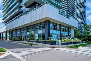 A modern multi-story building with a flat roof, large windows, and a central entrance.