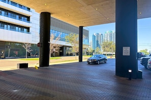 A parking area with a stop sign, a private property sign, and a building with a modern facade.