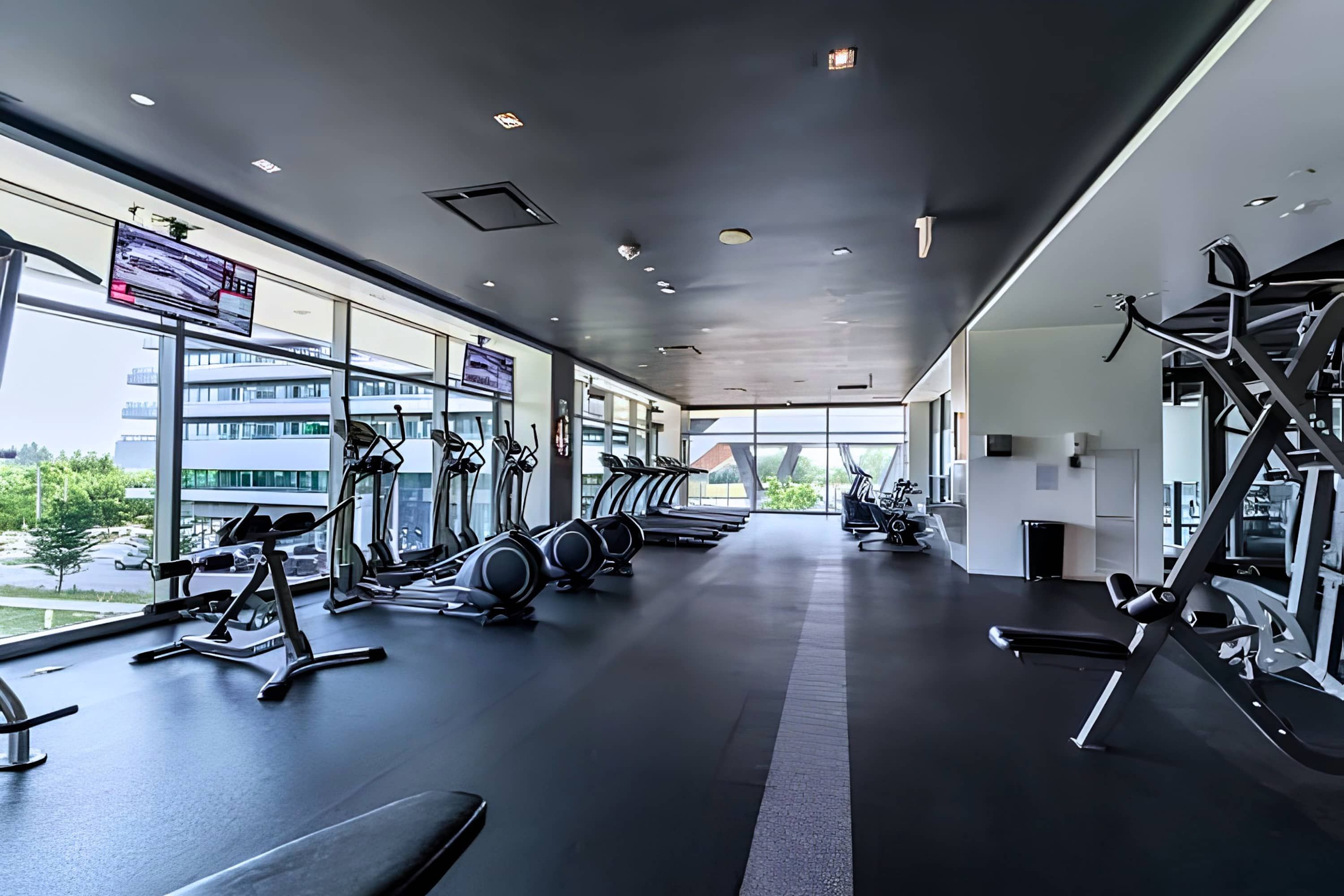 A gym with treadmills, elliptical machines, and weight equipment.