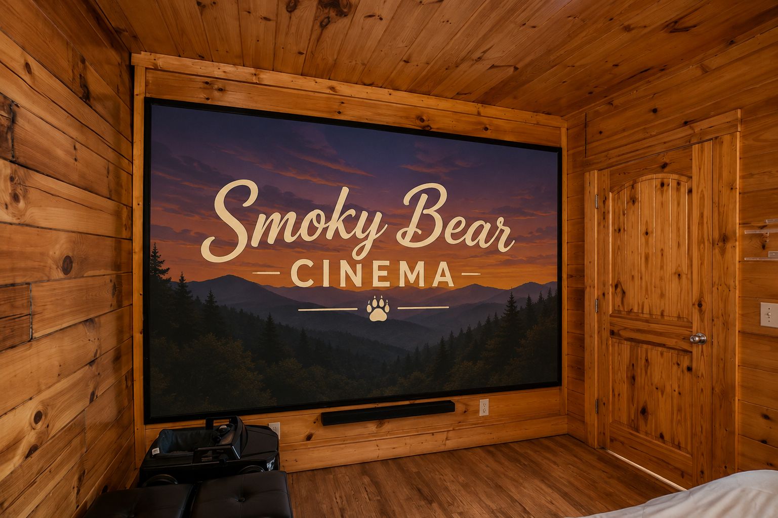 Una sala de cine con una pantalla grande mostrando 'Smoky Bear Cinema' y vistas a la montaña.