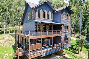 A multi-story log cabin with a balcony and a deck. - Private Indoor Pool + Theater + Game Room + Fire Pit | Sleeps 12 (Sevierviille)