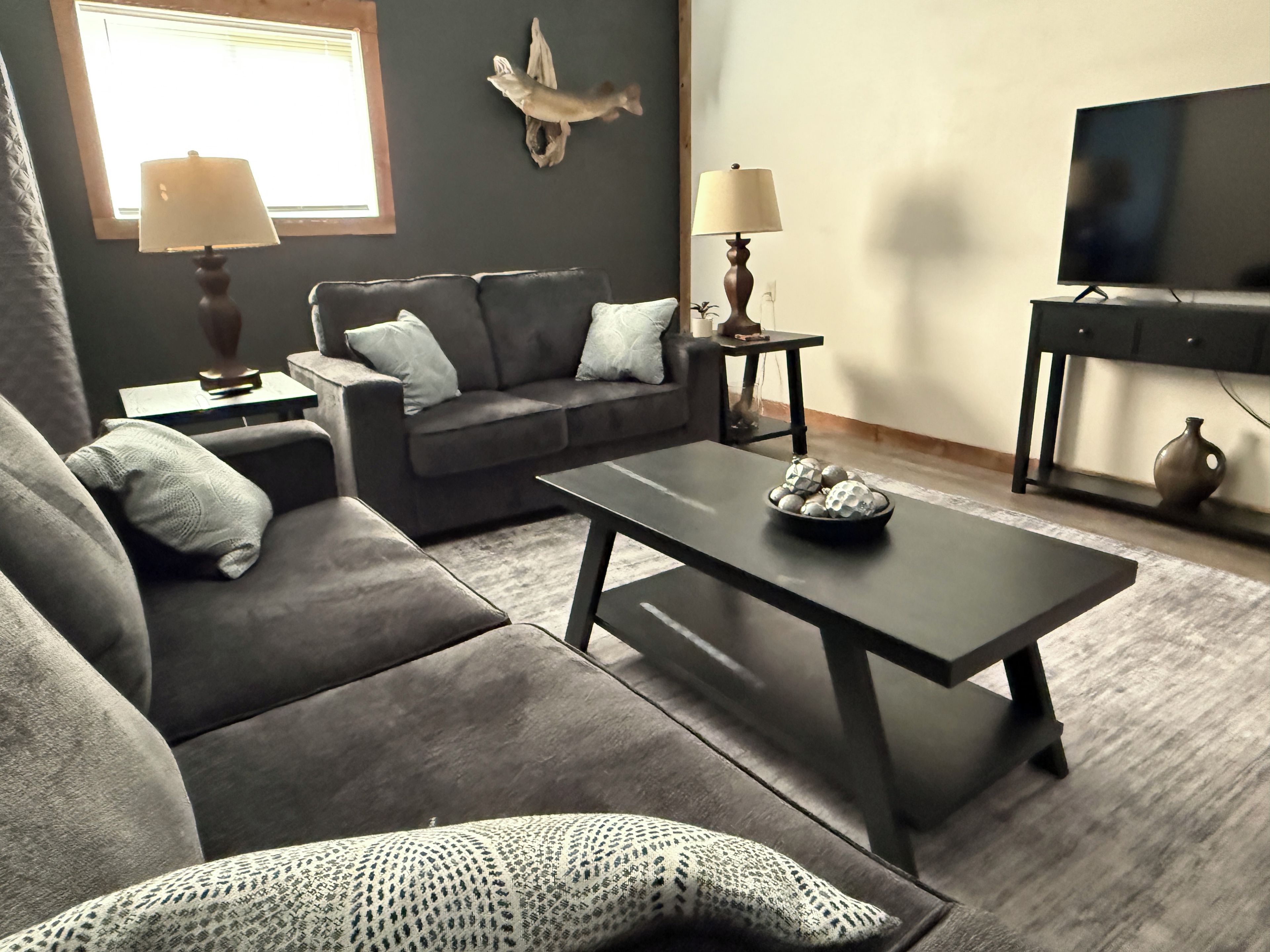 A living room with a sofa, coffee table, and a television.