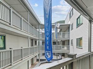 Een meerlaags gebouw met balkons en een blauwe banner met witte letters.