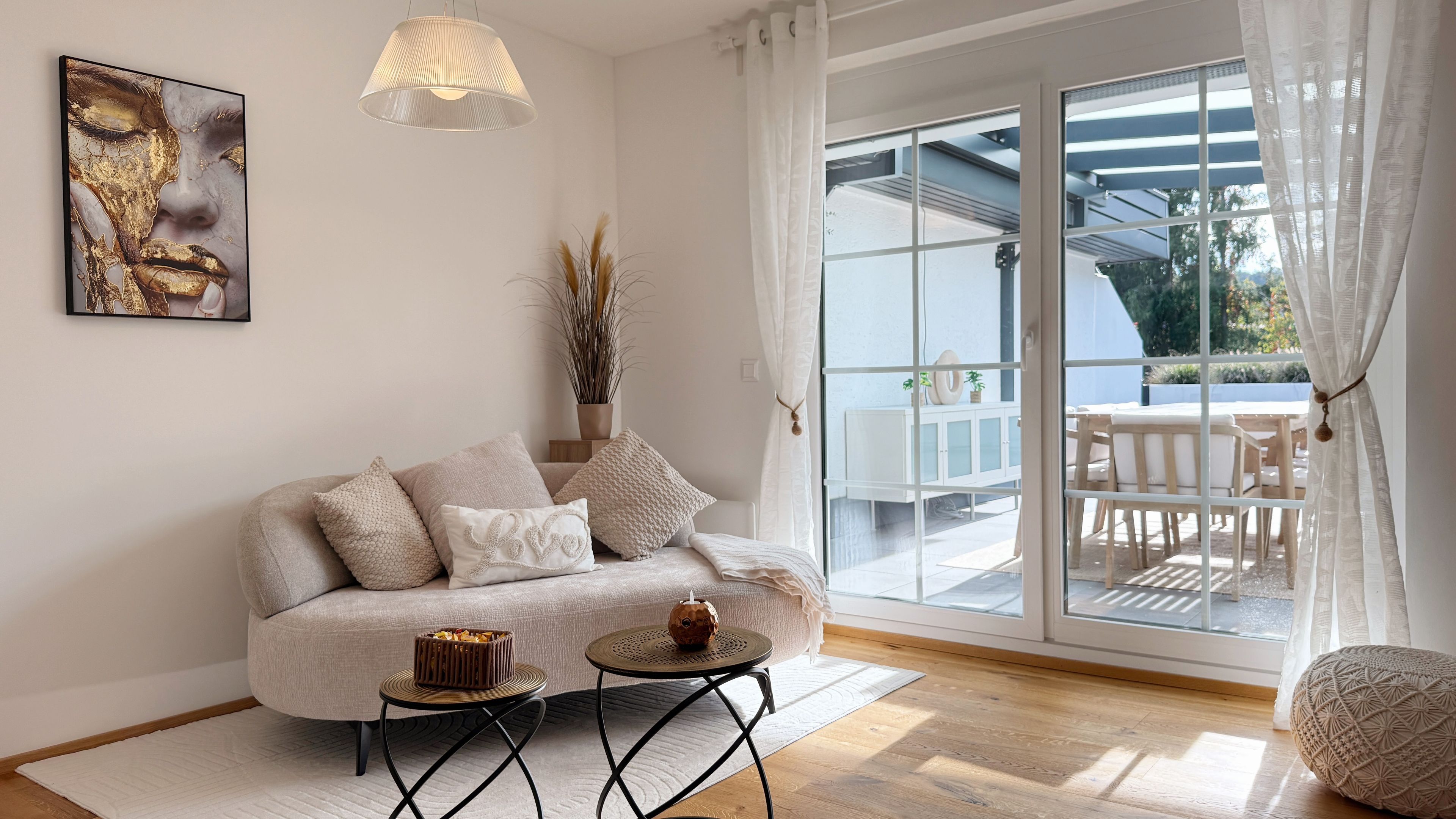 Un salon moderne avec un canapé, une petite table ronde et un objet décoratif posé sur la table.