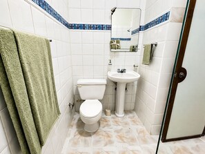 Ein Badezimmer mit Toilette, Waschbecken und Spiegel.